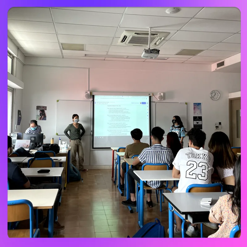 A classroom of high school students facing a projected slide during a club session.